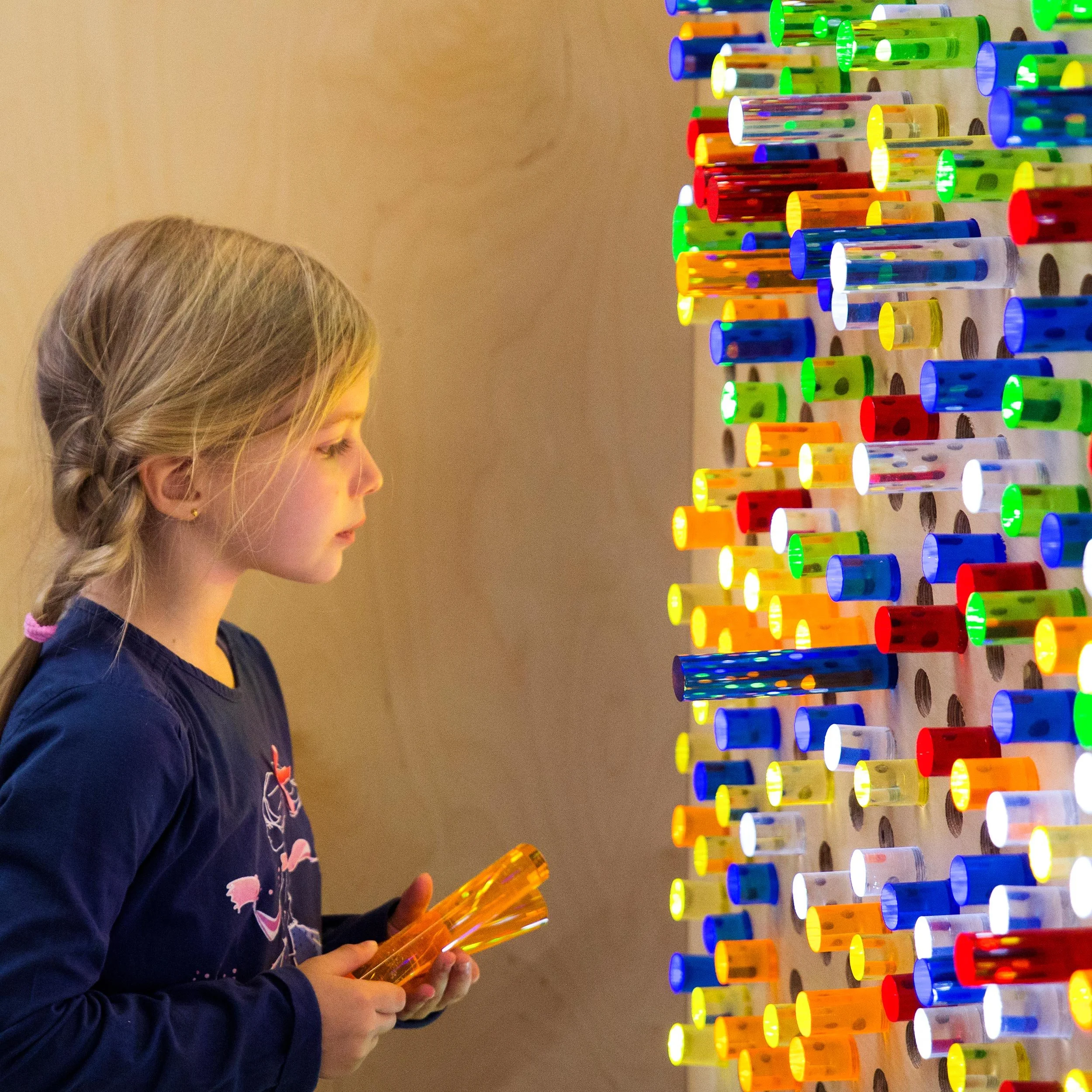 Niña explorando una actividad sensorial con botellas de colores en Columpio Playground, espacio de juego creativo para niños en Chamartín.