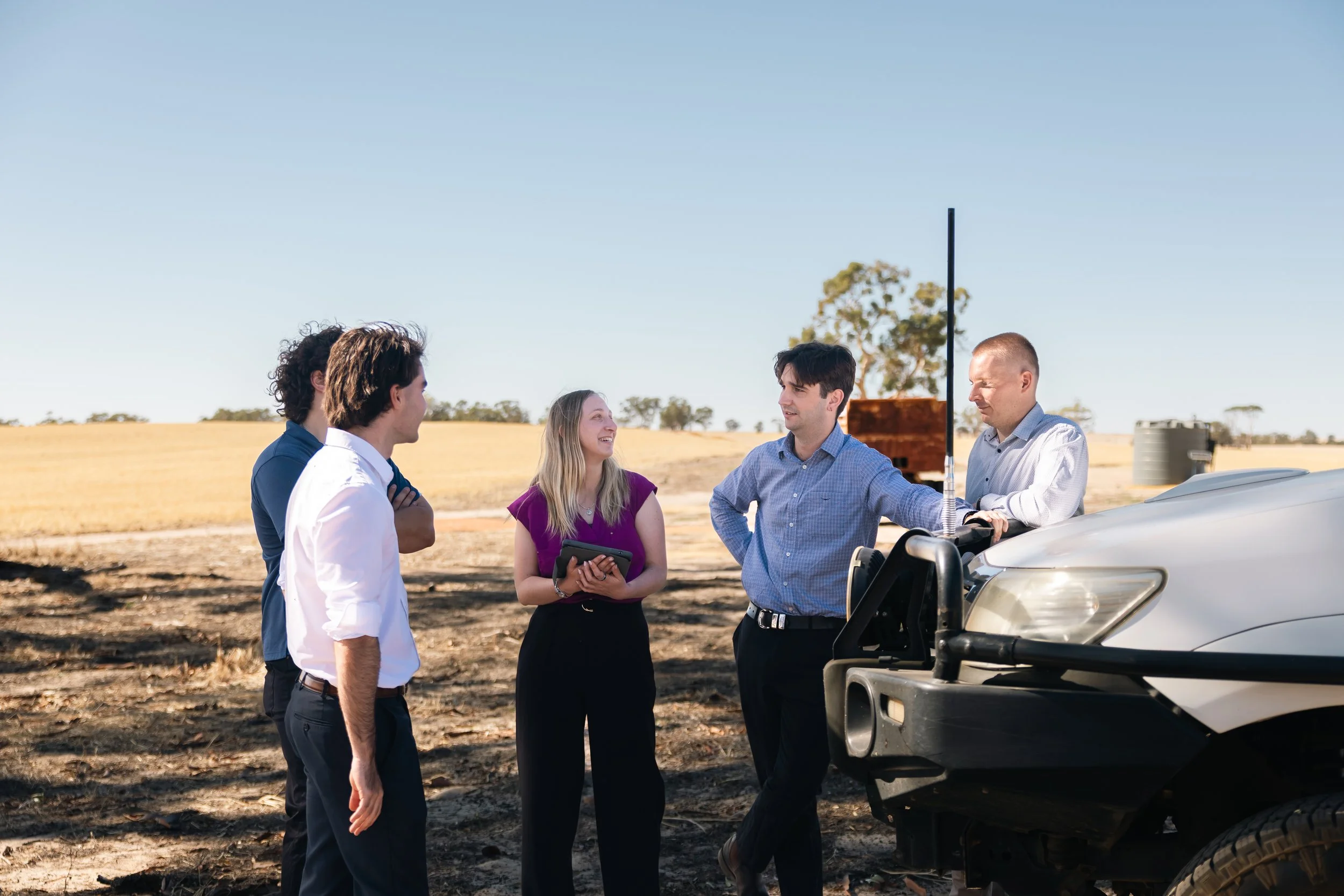 Byfields advisers talking with farmers beside a ute in a paddock