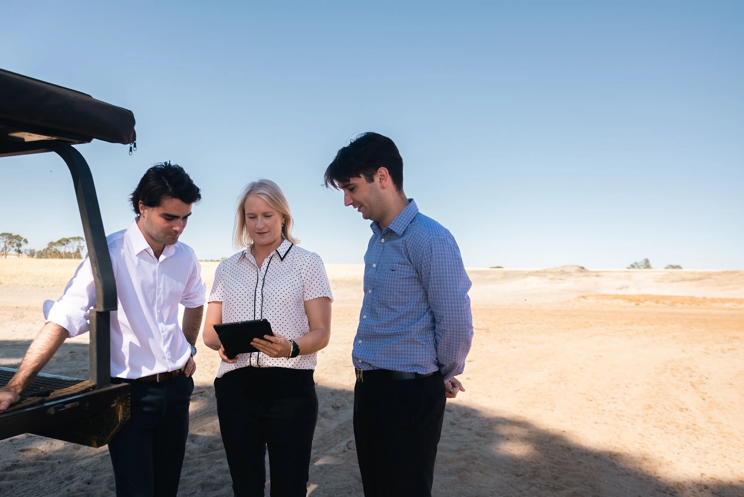 Byfields advisers reviewing documents beside a ute in a paddock