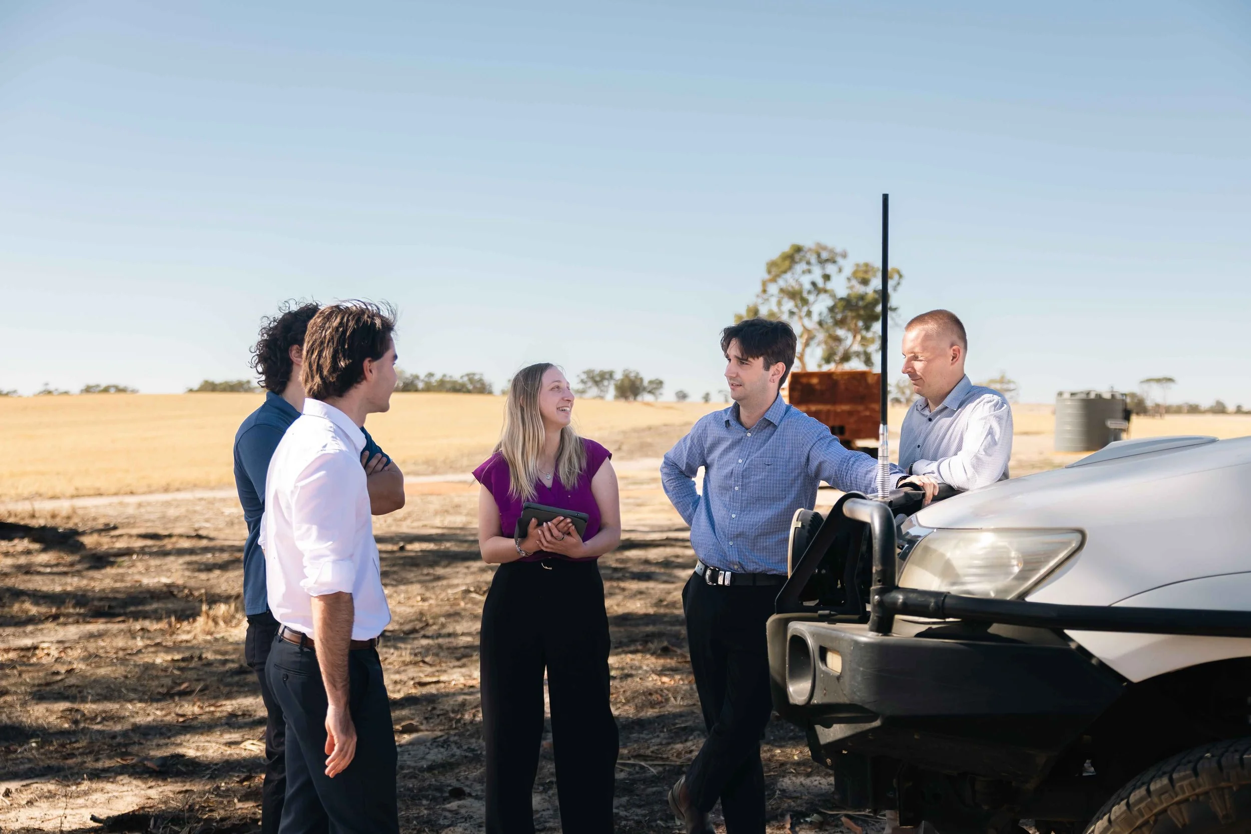 Byfields advisers talking with farmers beside a ute in a paddock