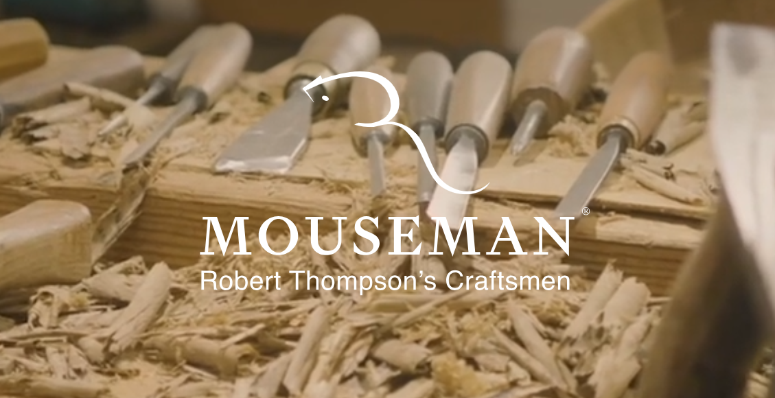Close-up of woodworking chisels on a workbench with wood shavings, with text overlay reading 'Mouseman: Robert Thompson's Craftsmen'.