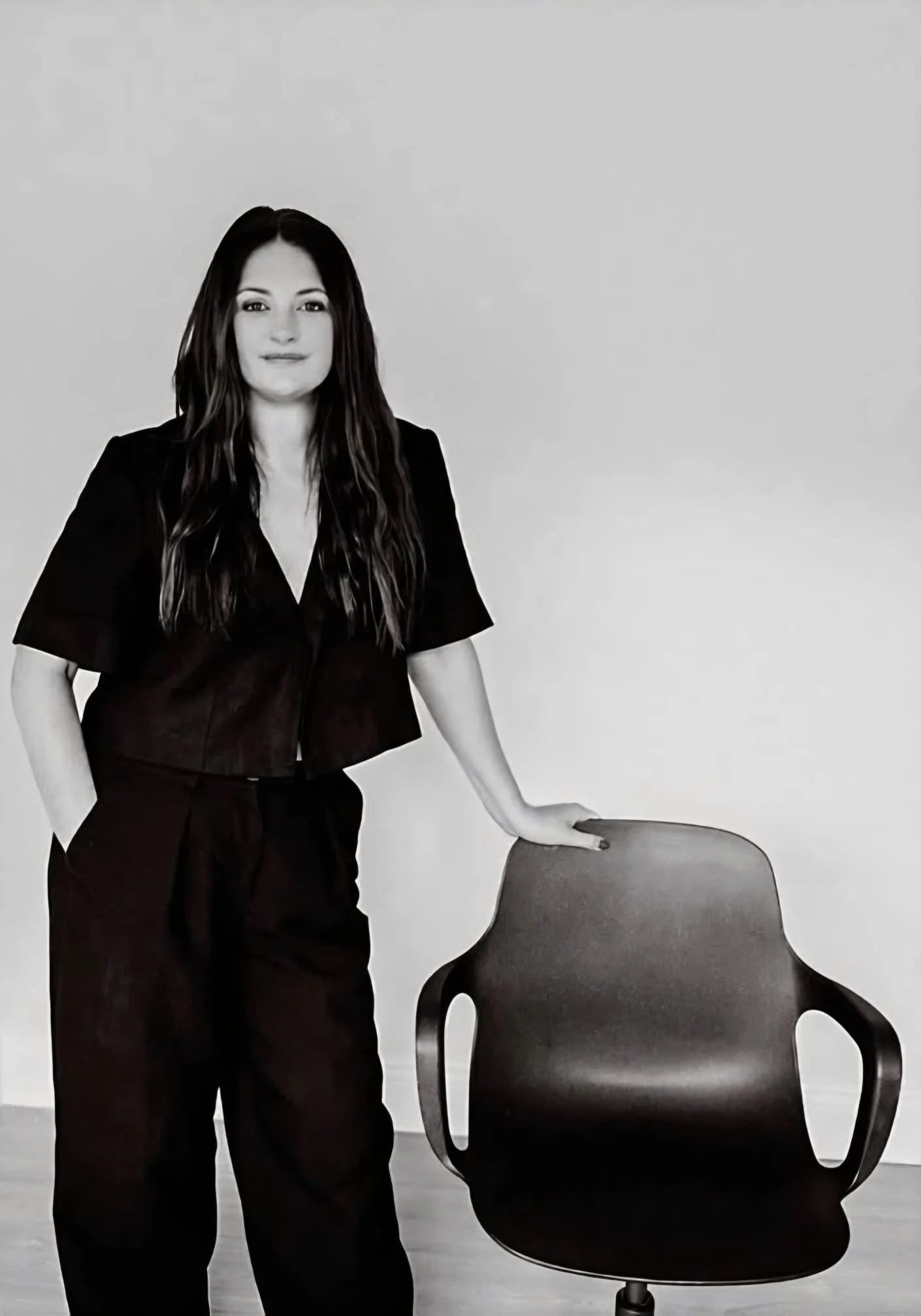 Clara Cashman standing leaning on a chair