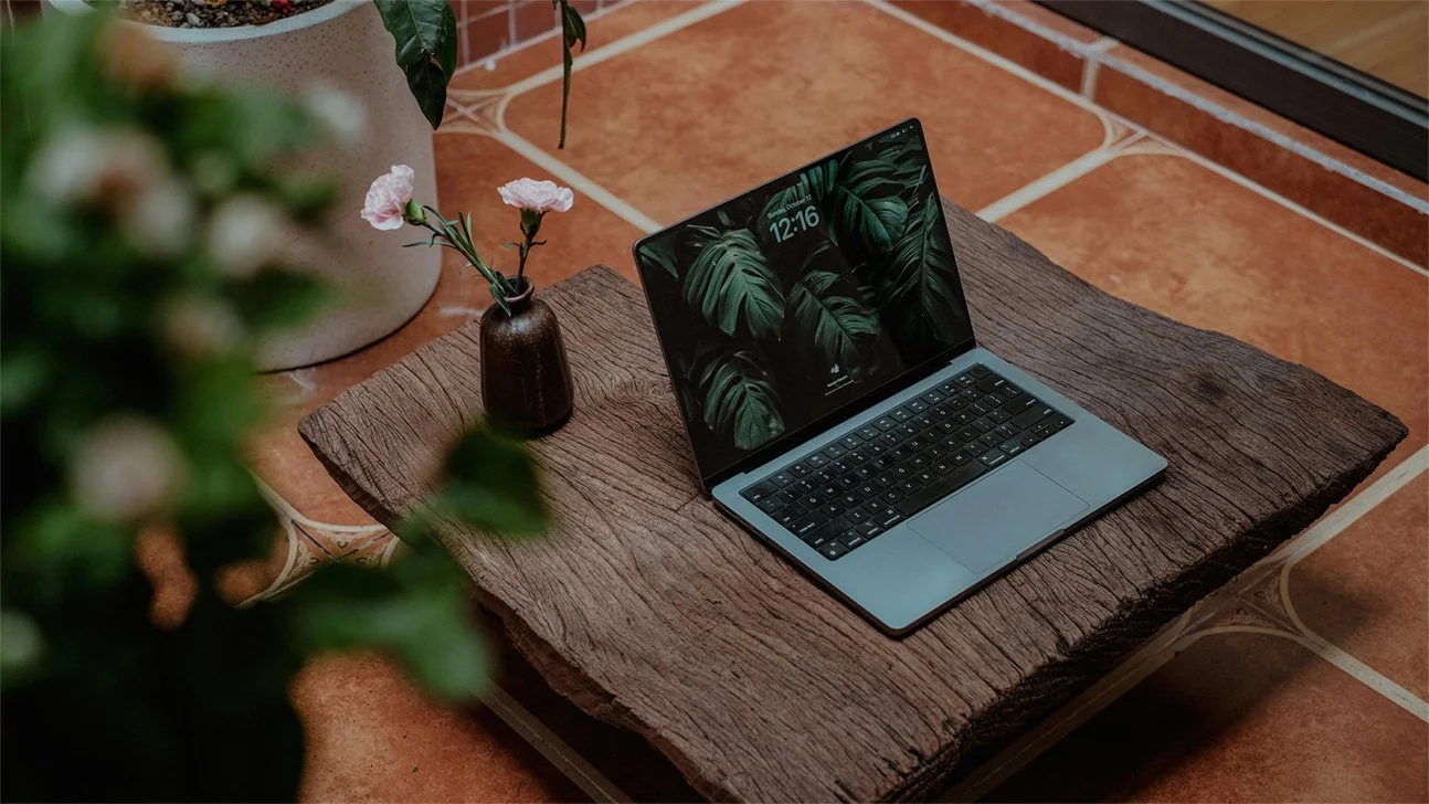 image d'un ordinateur sur une table en bois avec des plantes