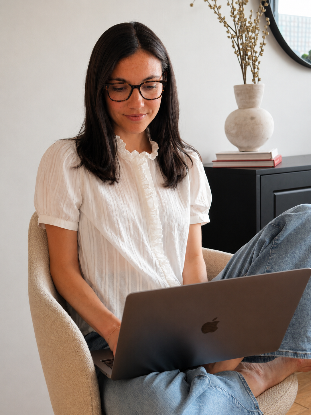 Alexa Nichols, registered dietitian, sitting in a chair and working on her laptop in a calm, bright space