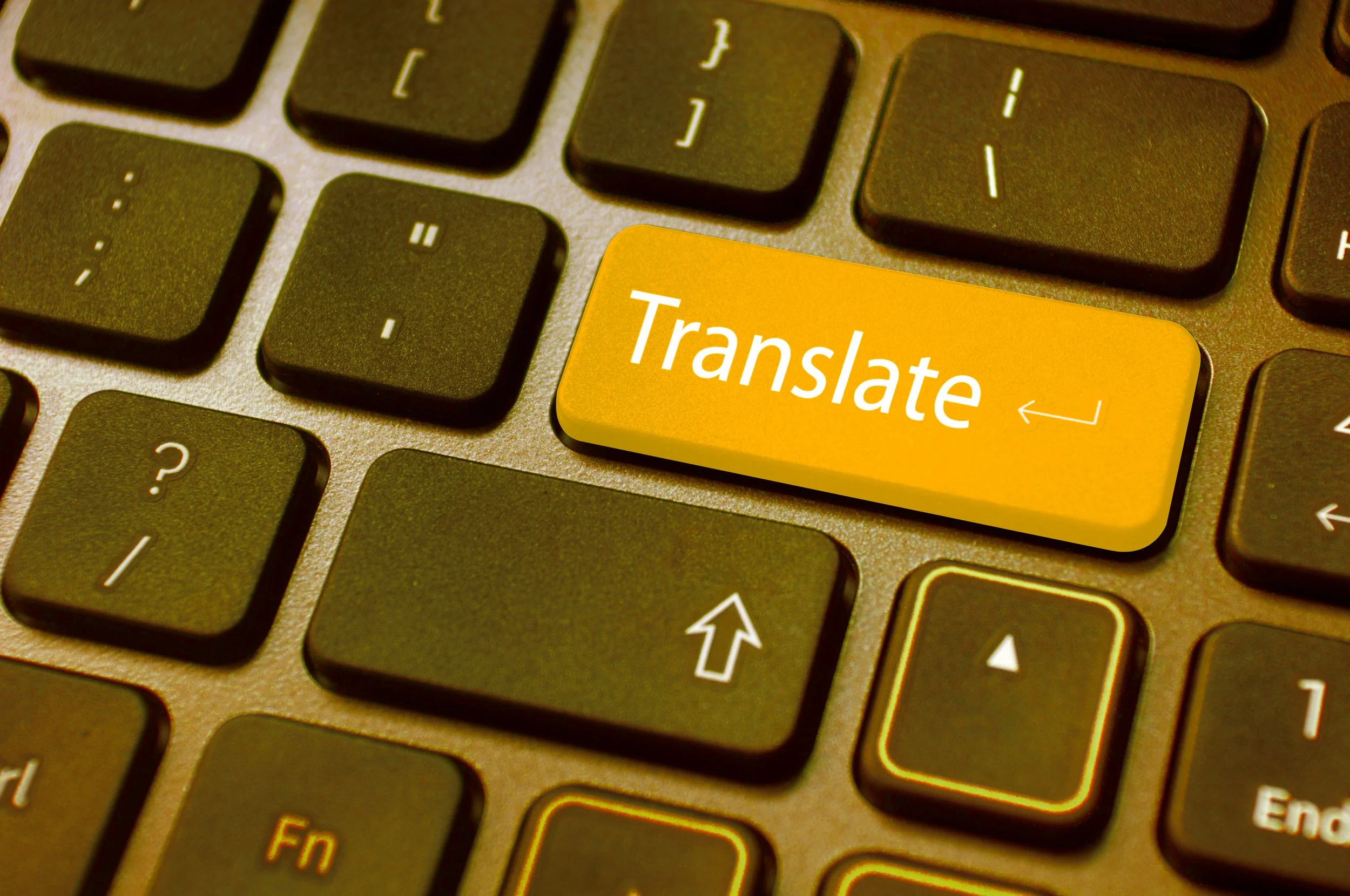 Close-up of a computer keyboard with a yellow key labeled 'Translate'.