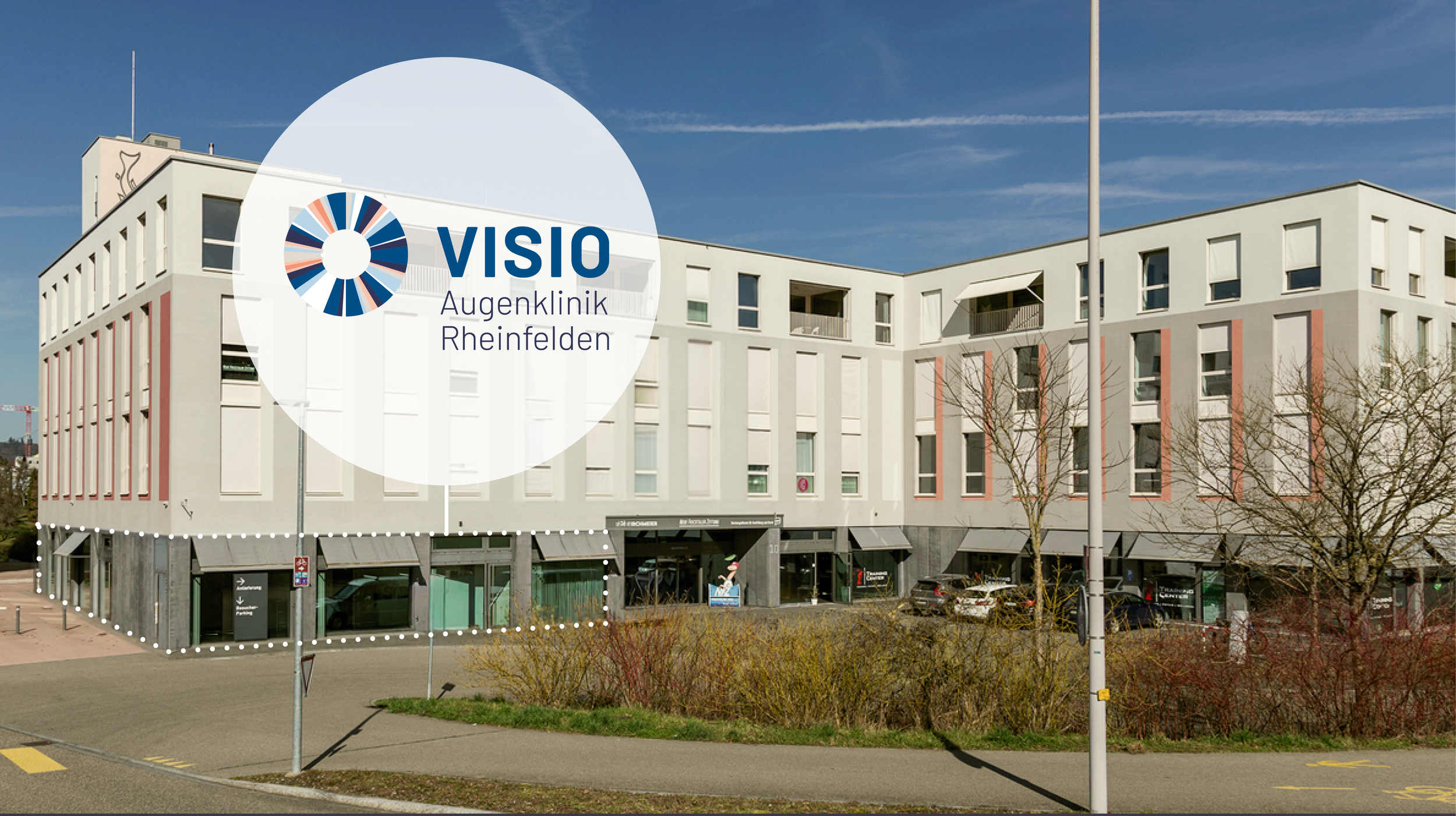 Außenansicht eines modernen Gebäudes mit einem Logo für die Augenklinik Rheinfelden auf einem weißen Kreis im Vordergrund.