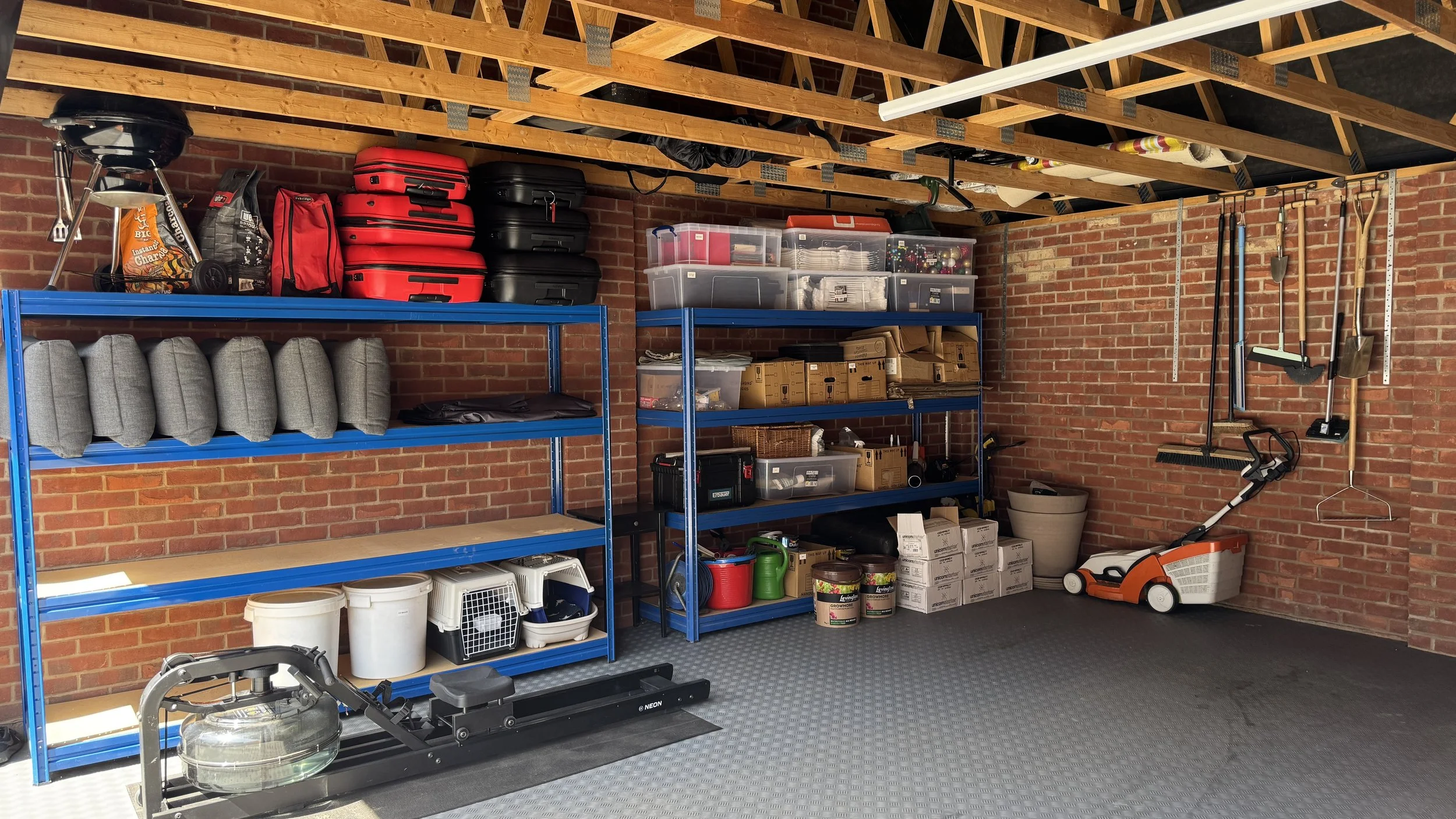 Organised garage storage with shelving, labelled containers and practical home organisation systems in East Sussex