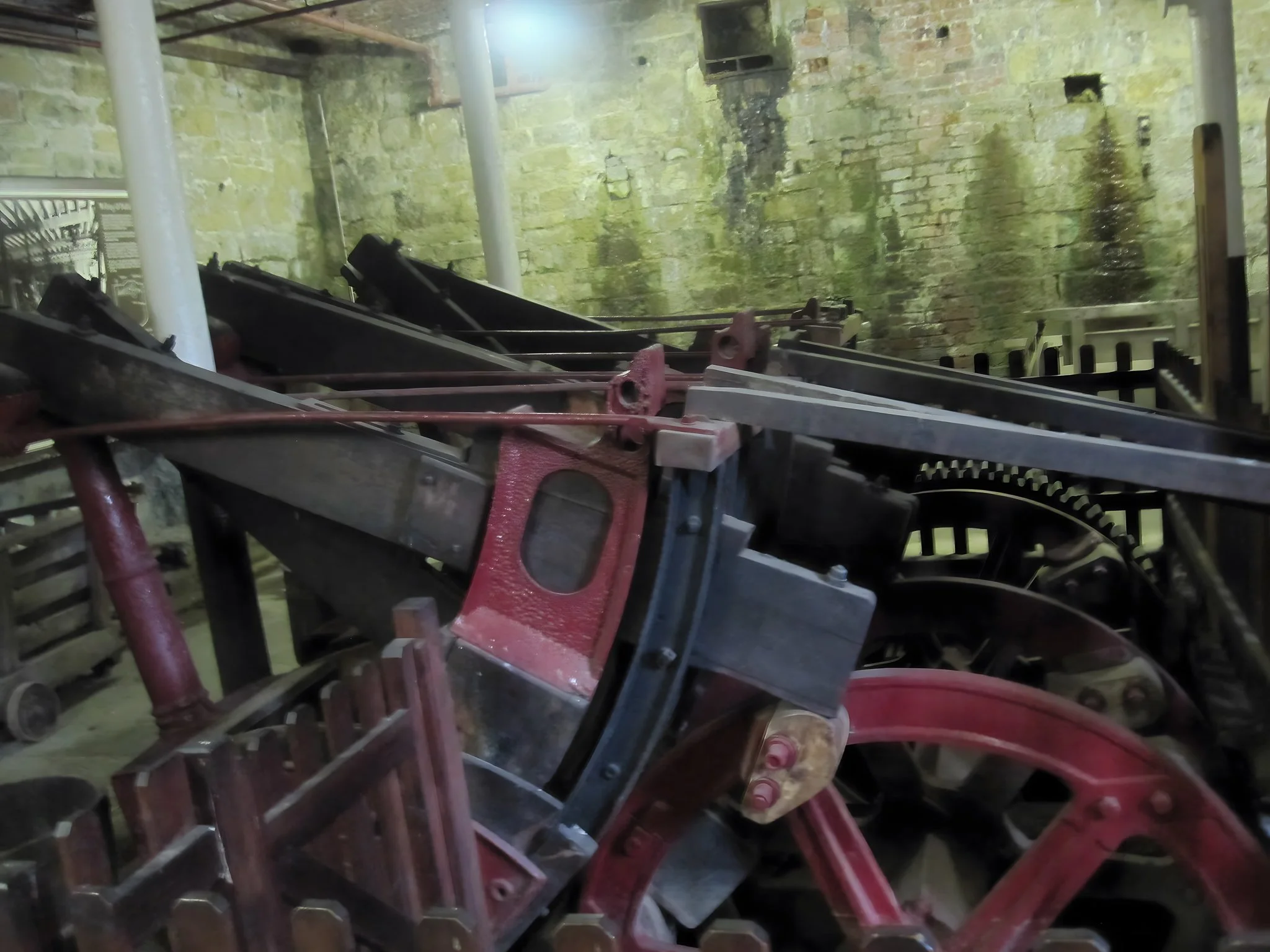Iron fulling mill arms at Leeds Industrial Museum, Armley Mills — red painted industrial machinery used for pounding cloth in wool textile production