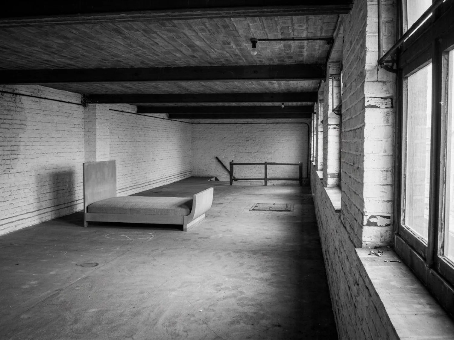 Minimalist warehouse conversion in Flanders, Belgium, transforming a historic industrial building into contemporary office space through adaptive re-use