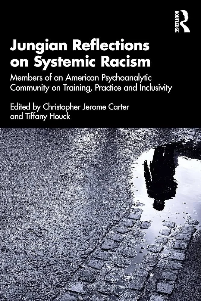 Book cover titled 'Jungian Reflections on Systemic Racism' with black background and a reflection of a person in a puddle on a cobblestone street.
