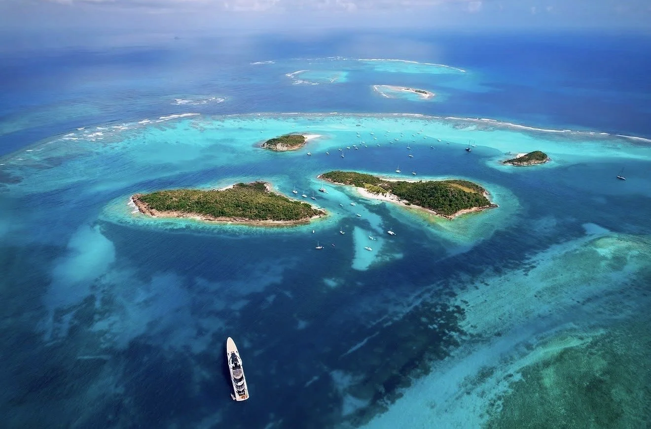 Aerial view of tropical islands surrounded by vibrant blue ocean with boats docked near the islands