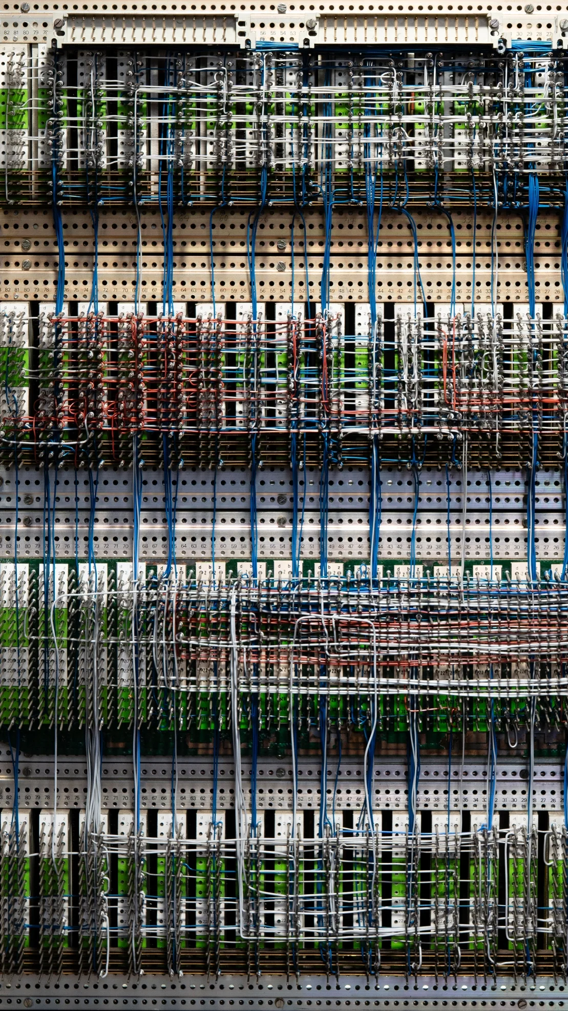 Blick auf eine große, komplexe Steuerungstafel mit vielen bunten Kabeln, Schaltern und Steckverbindungen.