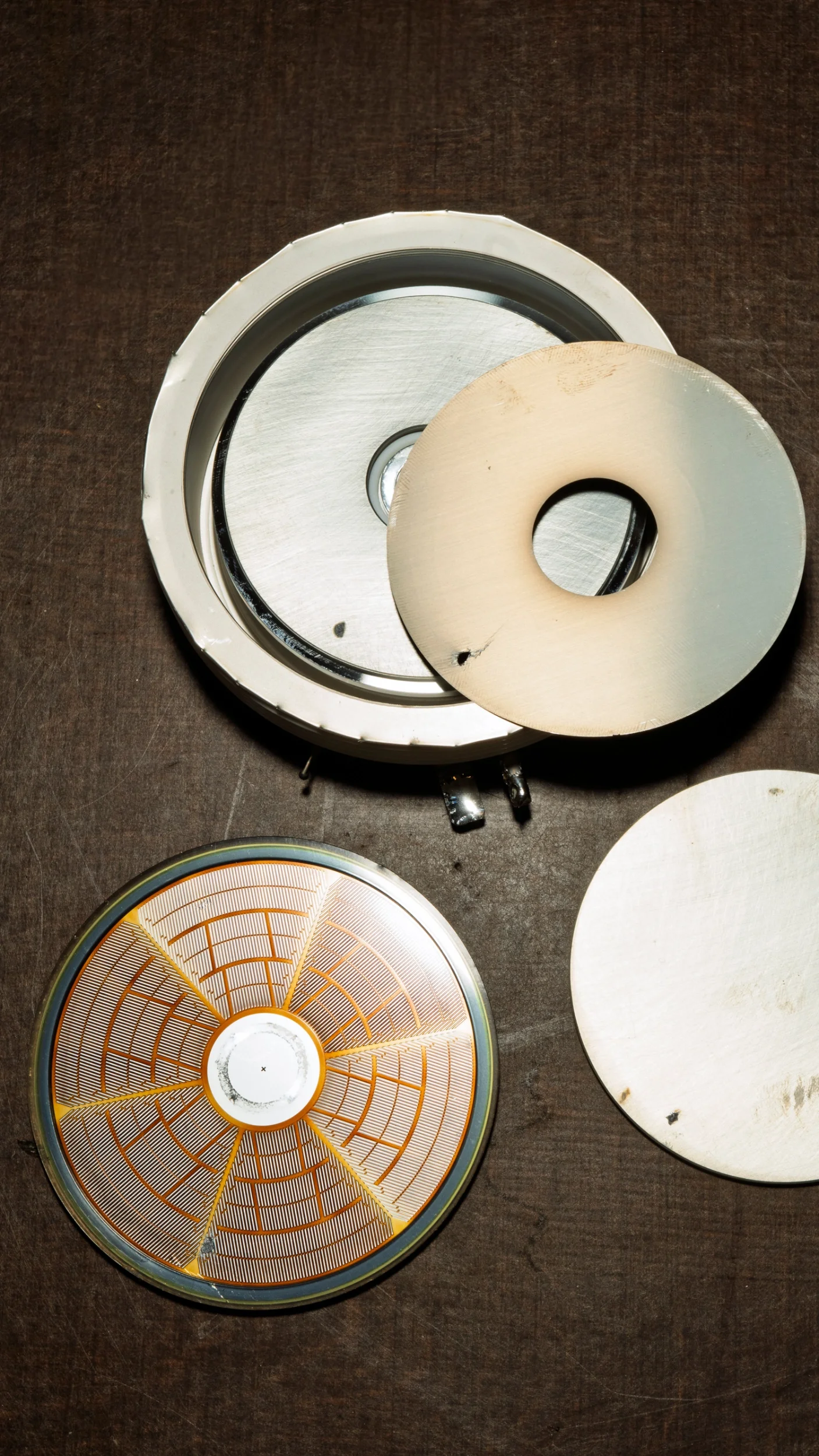 Verschiedene Detektorteile und Platten, die für die Wartung oder Reparatur benutzt werden, auf einer dunklen Oberfläche.