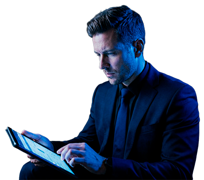 Man in dark suit using a tablet against a dark background.