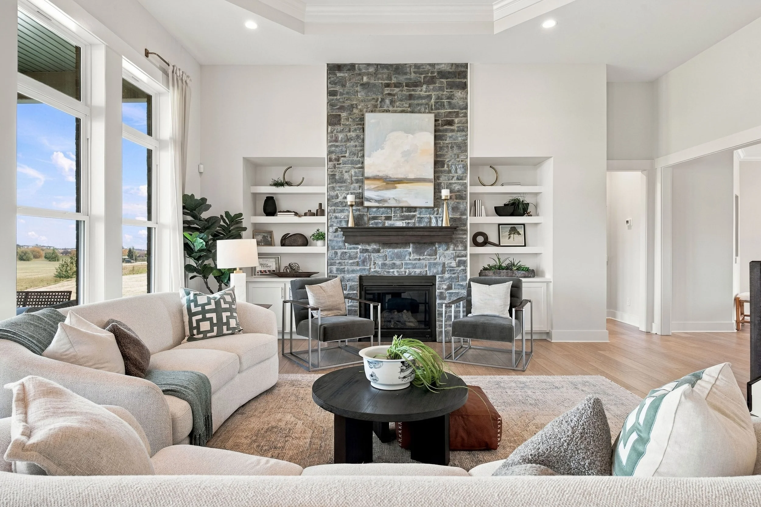 Living room with stone fireplace and built in shelving photographed for residential real estate marketing Primary bedroom: