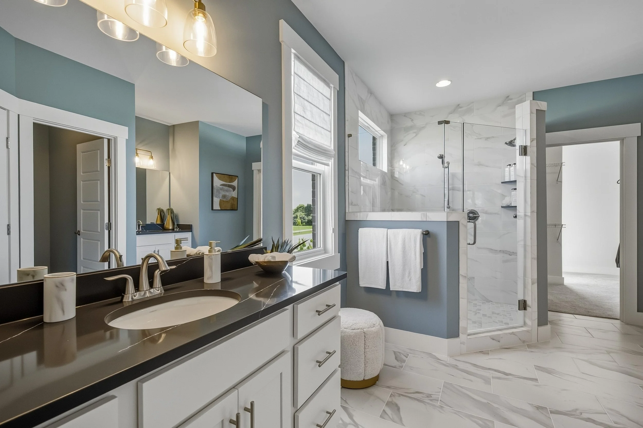 Primary bathroom with glass shower and double vanity photographed for residential real estate marketing