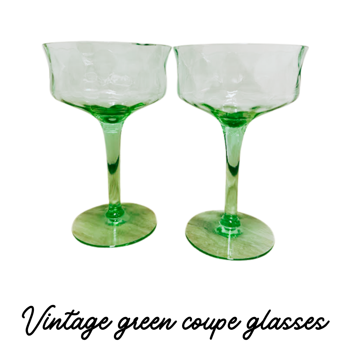 Two green-glass cocktail glasses with wide bowls and long stems, positioned next to each other on a flat surface.