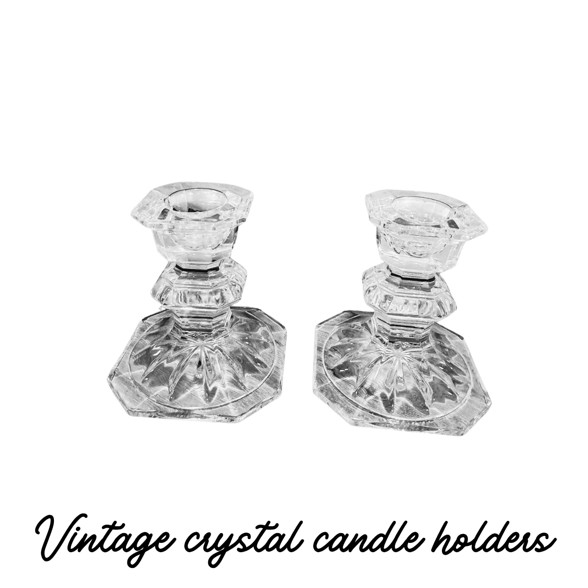 Pair of clear, ornate crystal candle holders on a black background.