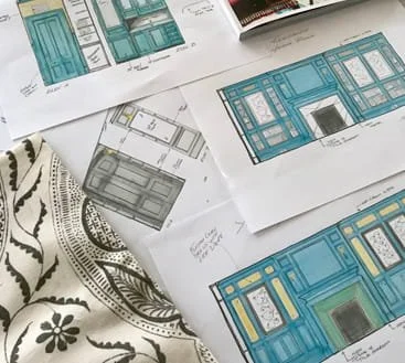 Hand drawings of a blue book case with fabric samples on a table.
