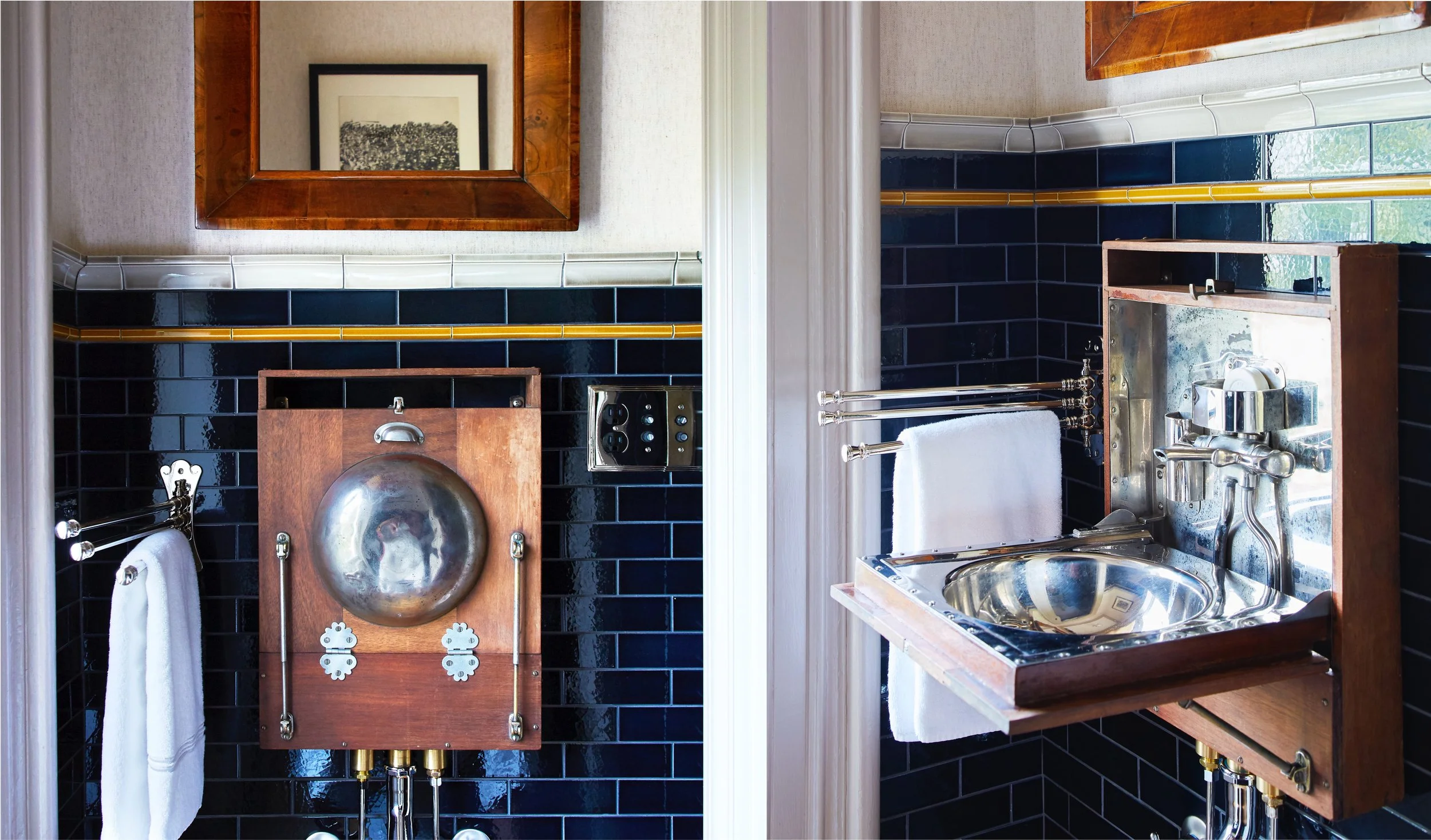 A vintage bathroom with black tiled walls, a small sink with a chrome faucet, an antique metal washbasin mounted on a wooden board, framed mirror, and white towels.
