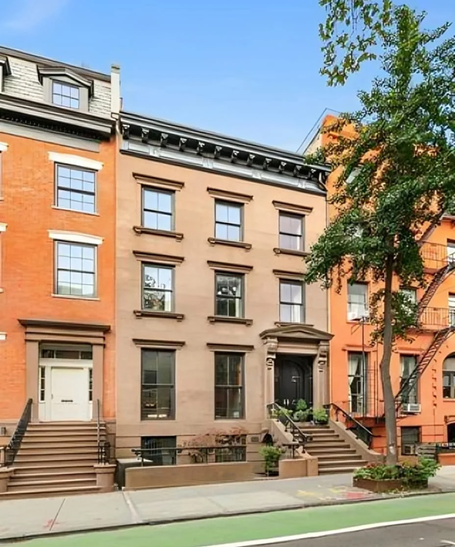 Three adjacent city buildings with brownstone and brick facades, steps leading to entrances, trees, and a sidewalk.