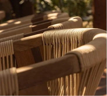 Close-up of wooden chairs with woven seats and backs.