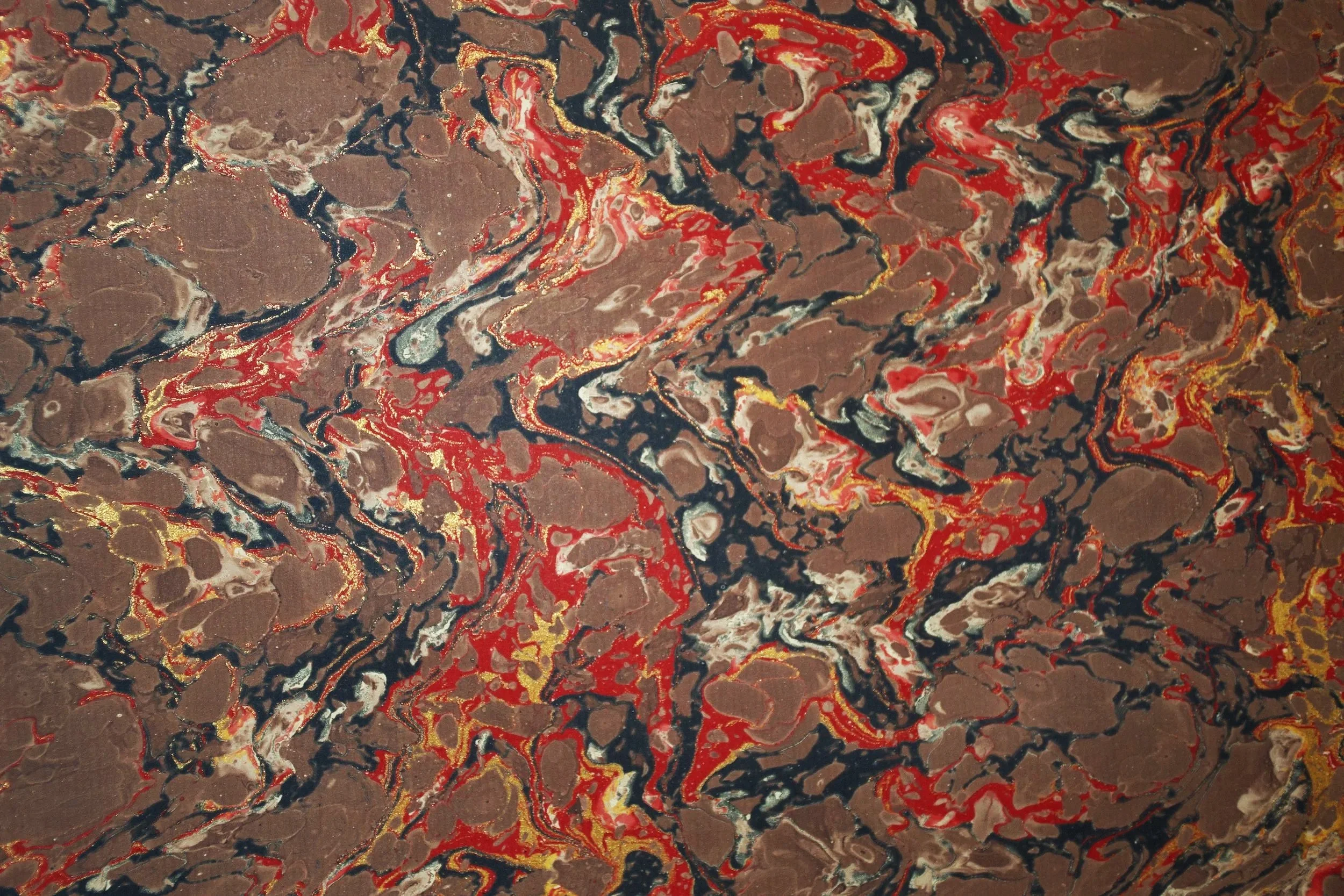 Carta fiorentina marrone con marmorizzazione decorativa nei toni del nero, rosso bianco e oro