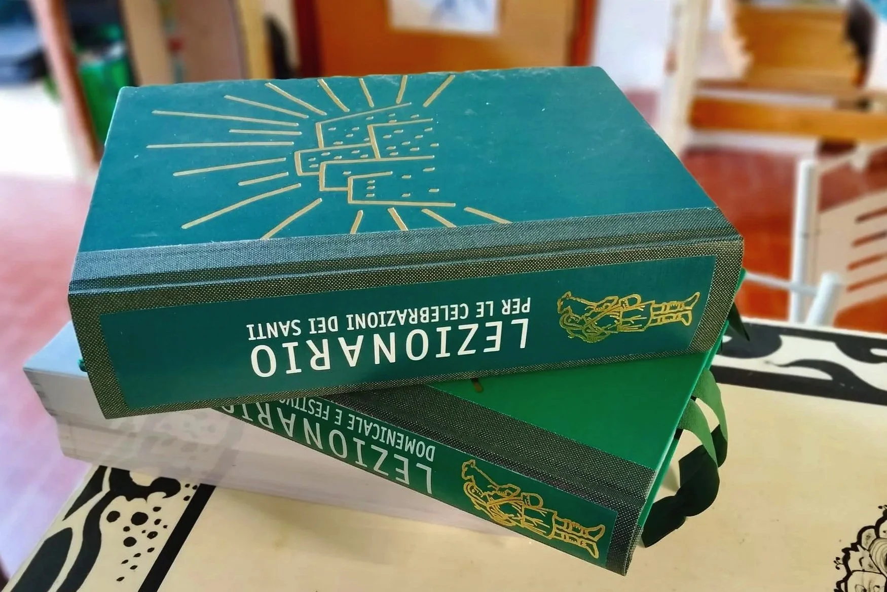 Foto di un lezionario restaurato con copertina originale in ecopelle verde, decorata da un motivo dorato, e dorso in buckram verde. Sul dorso è stata applicata la toppa del dorso originale, conservata durante il restauro.