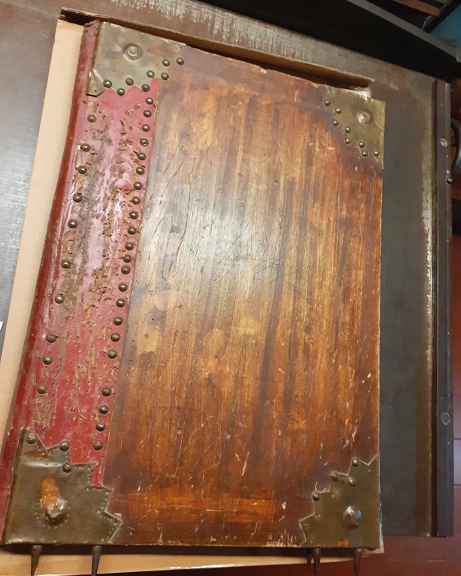 Copertina di legno inchiodata di un antico manoscritto del 1400 in pergamena, con chiodi metallici visibili sulla superficie.