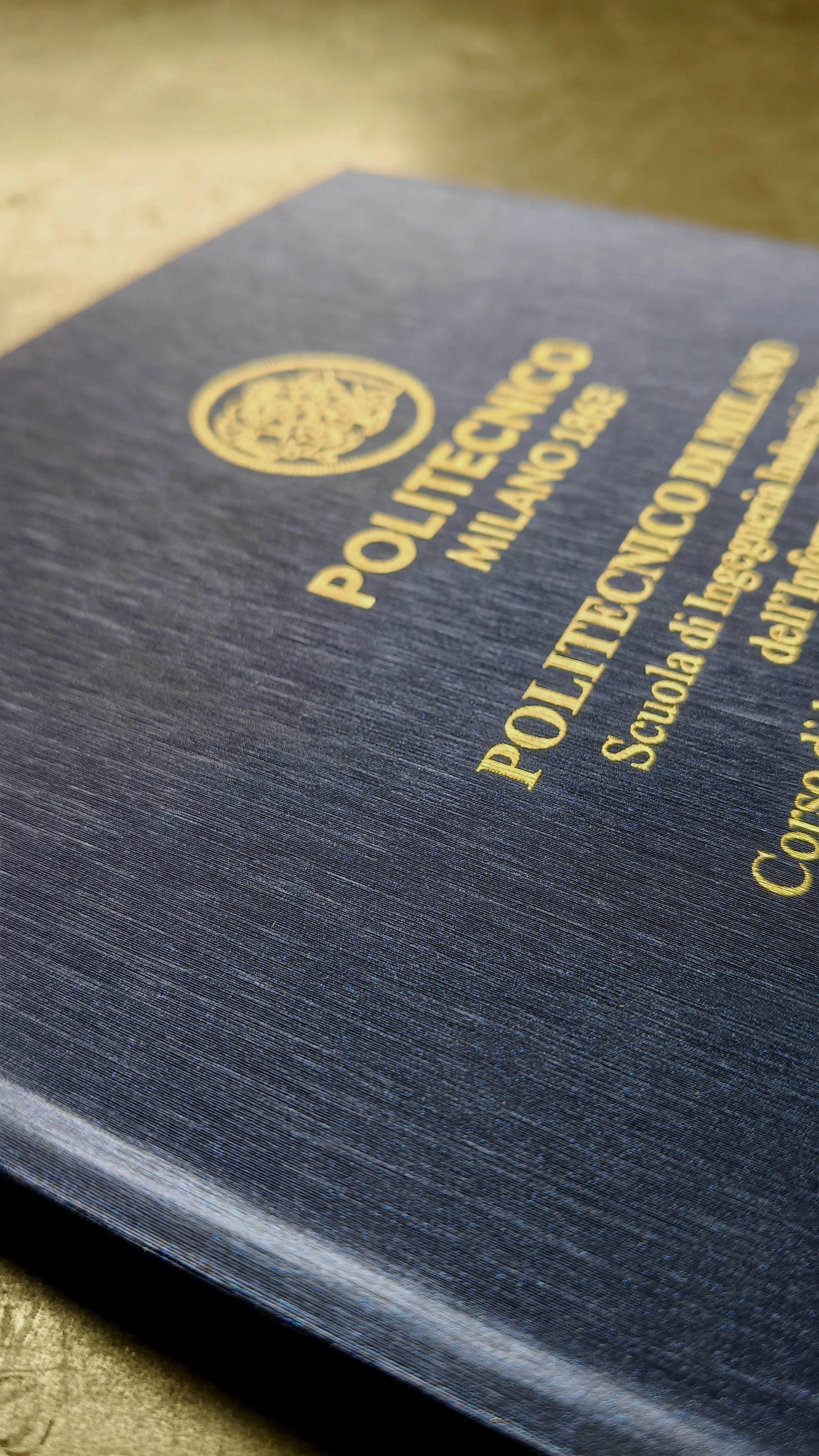 Tesi cartonata. Materiale: rigato blu. Scritta: foglia d'oro.