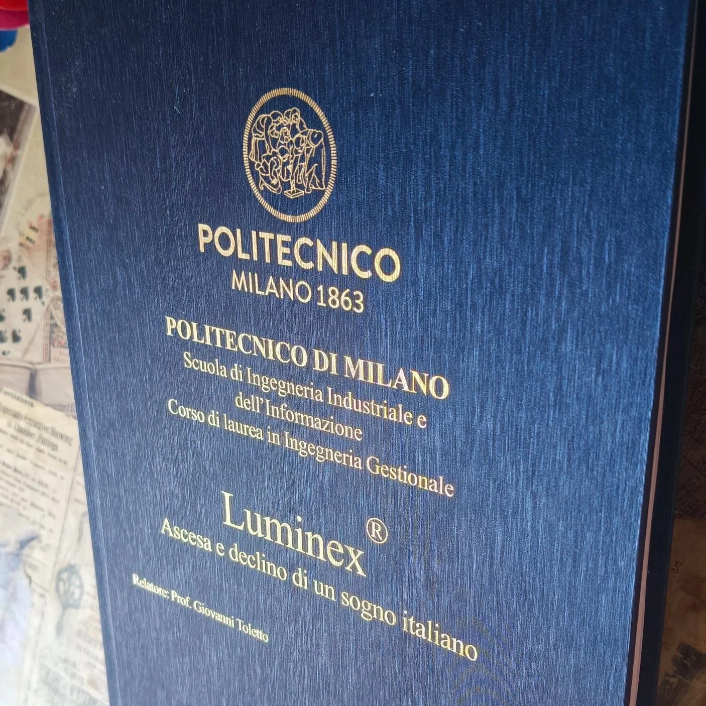 Tesi cartonata. Materiale: rigato blu. Scritta: foglia d'oro.