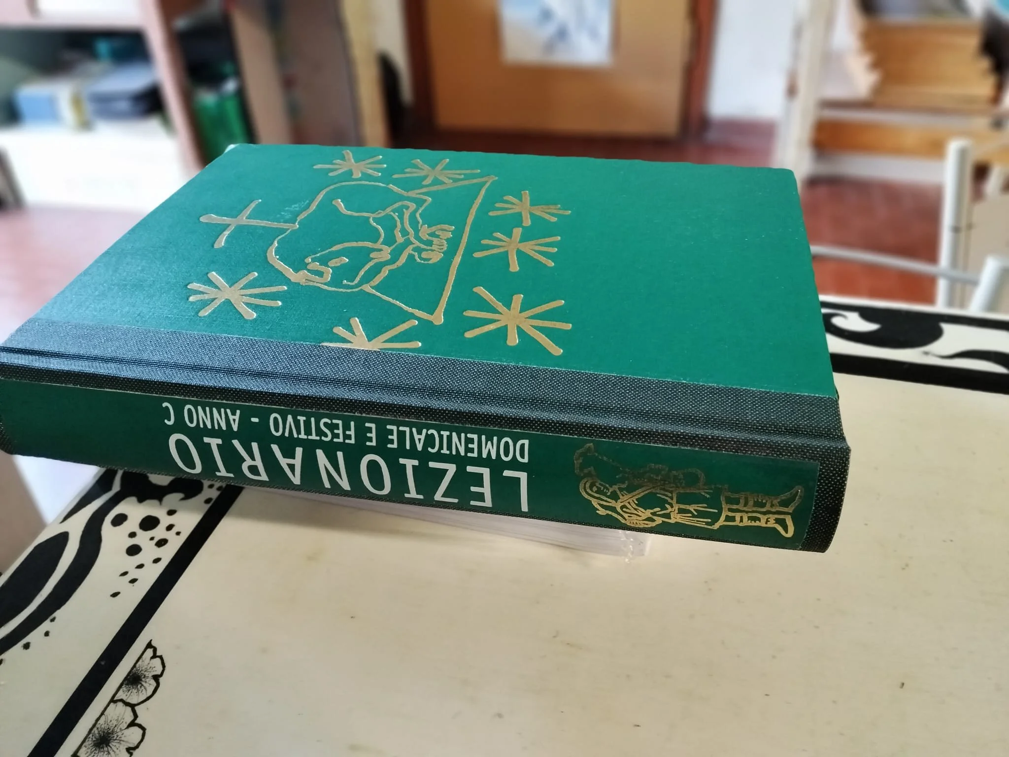 Foto di un lezionario restaurato con copertina originale in ecopelle verde, decorata da un motivo dorato, e dorso in buckram verde. Sul dorso è stata applicata la toppa originale, conservata durante il restauro
