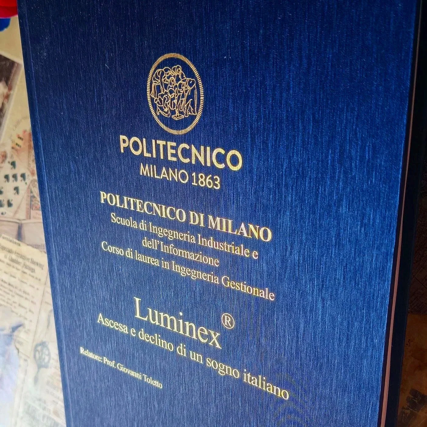 Tesi del Politecnico di Milano con rilegatura cartonata, copertina in ecopelle blu effetto rigato e titolo realizzato in foglia d’oro.