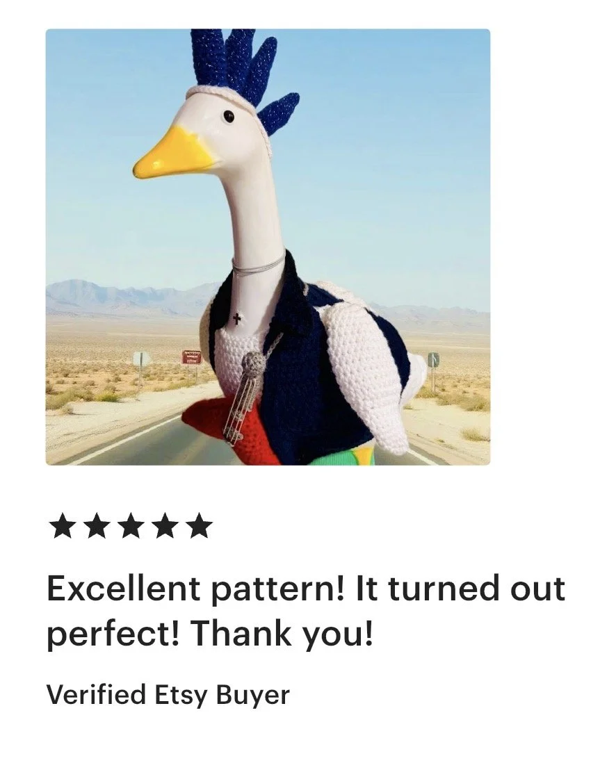A large, anthropomorphic goose with a colorful, knitted body dressed as a human in a desert landscape.