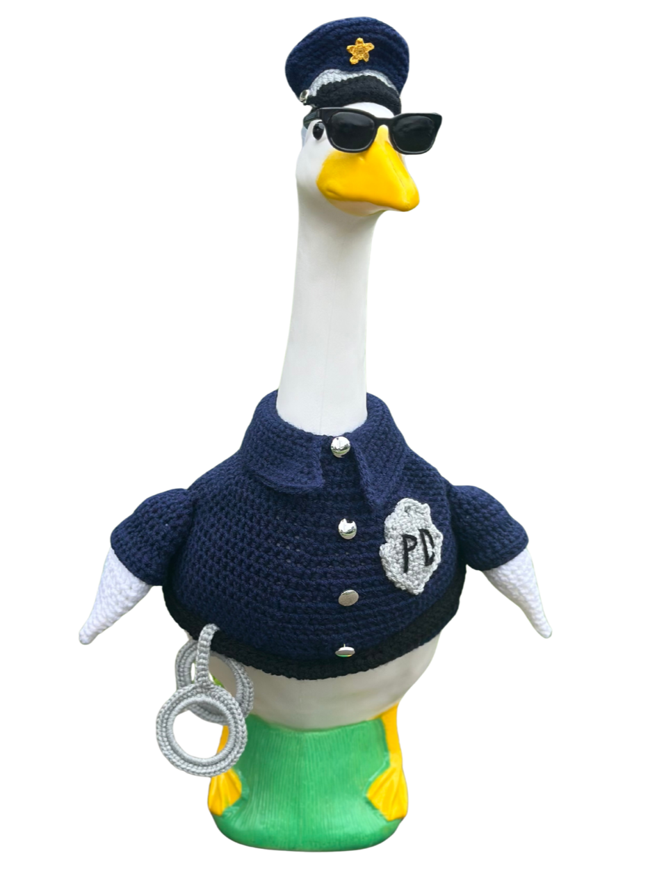 A decorative goose sculpture dressed as a police officer with sunglasses, a navy blue uniform, and a police hat, standing on a green base.