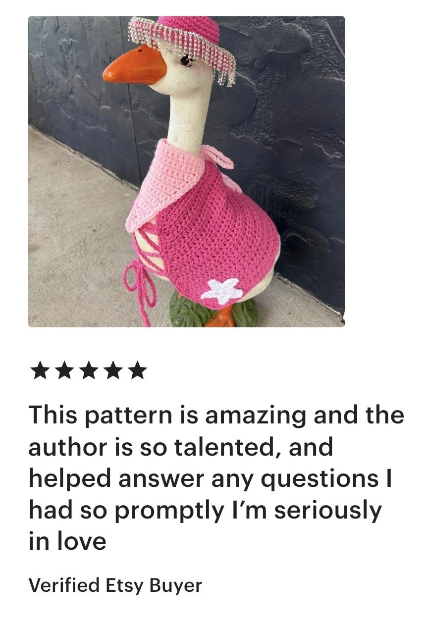 Decorative statue of a goose dressed in a pink crocheted dress and a pink hat with beads.