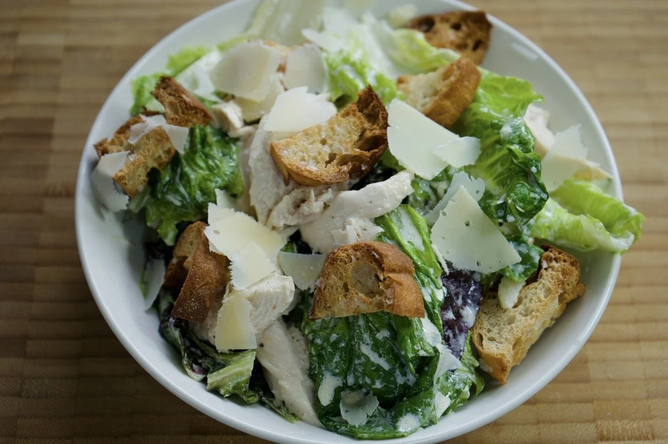 chicken Cesar salad dressed with croutons and shaving of parmesan