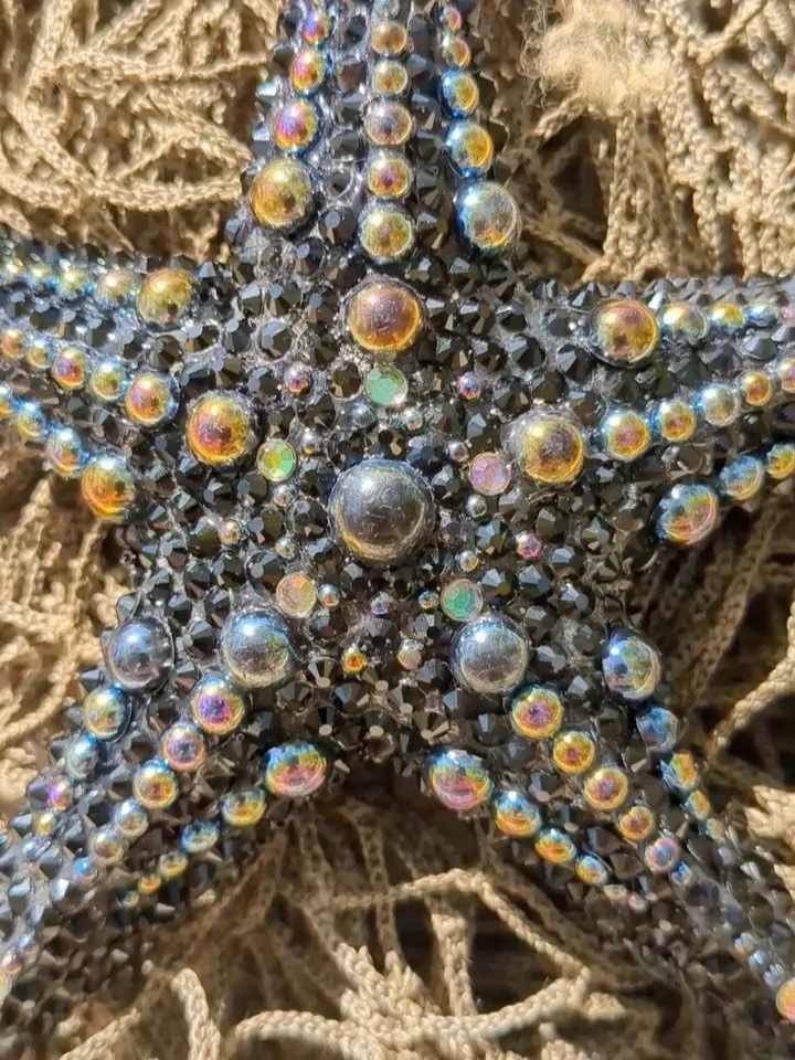 she looks like a starfish because she IS one. 

the underside is covered in glass seed breads and bugle beads standing on end, hand placed one by one, representing the tubular feet and ambulacral groove of an actual starfish. as they approach the mou