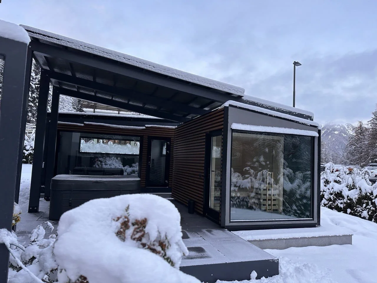Casa moderna con grandi finestre circondata da neve in montagna