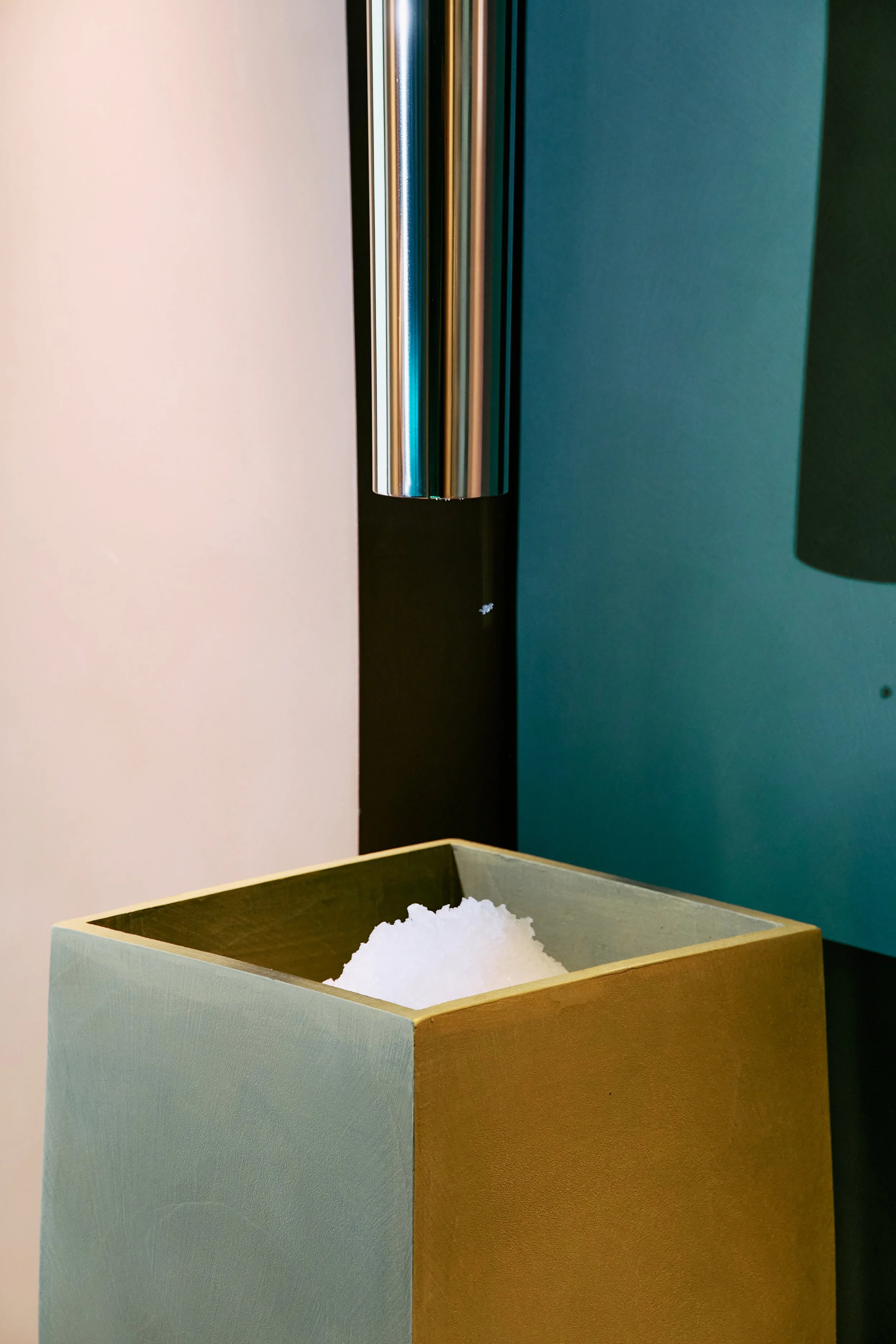 Un barattolo di sale con sale bianca e un contenitore di sale grosso, decorazioni minimaliste in uno stile moderno, pareti verdi e beige.