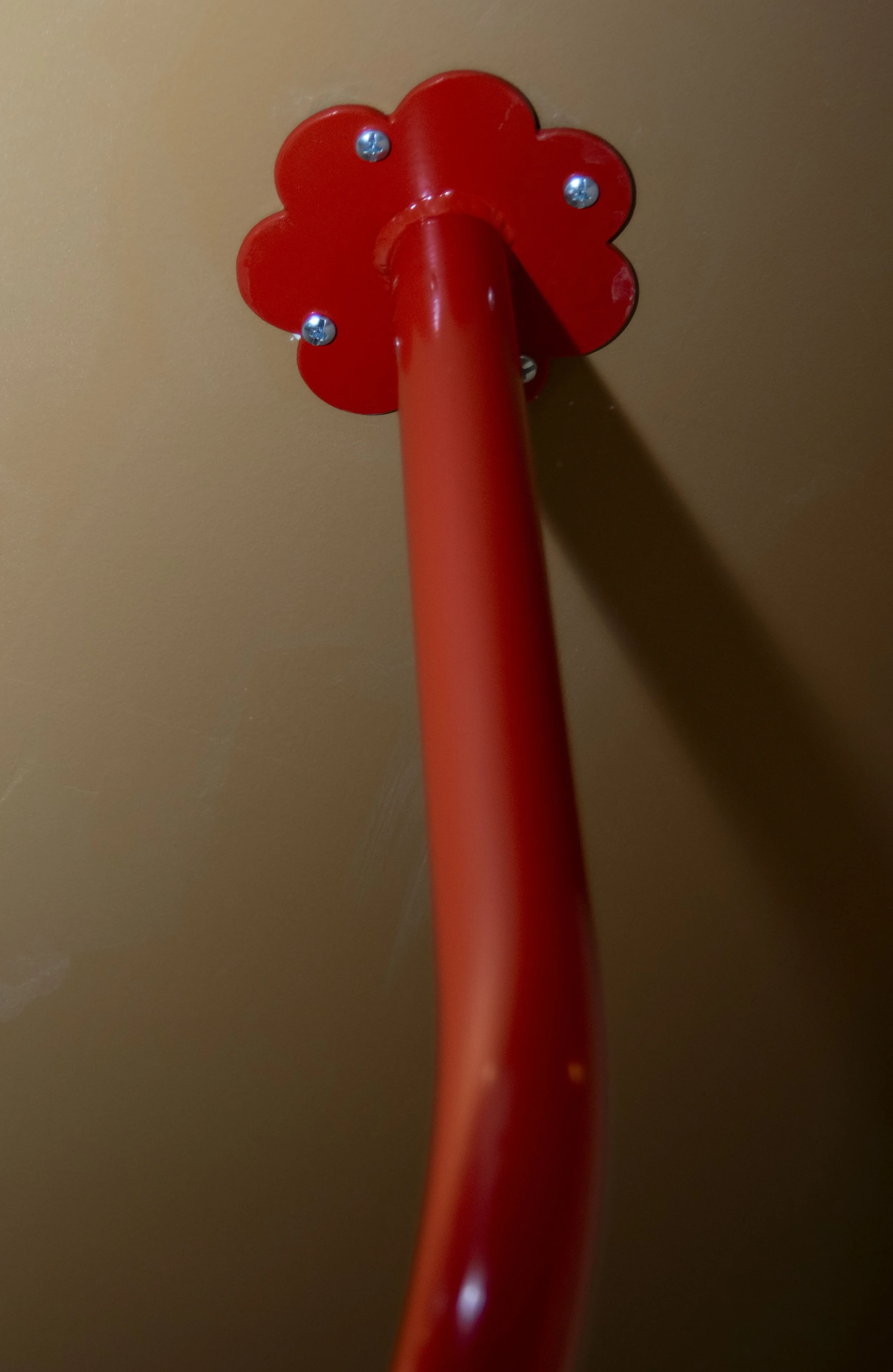 Red clothing bar mounting into tan ceiling