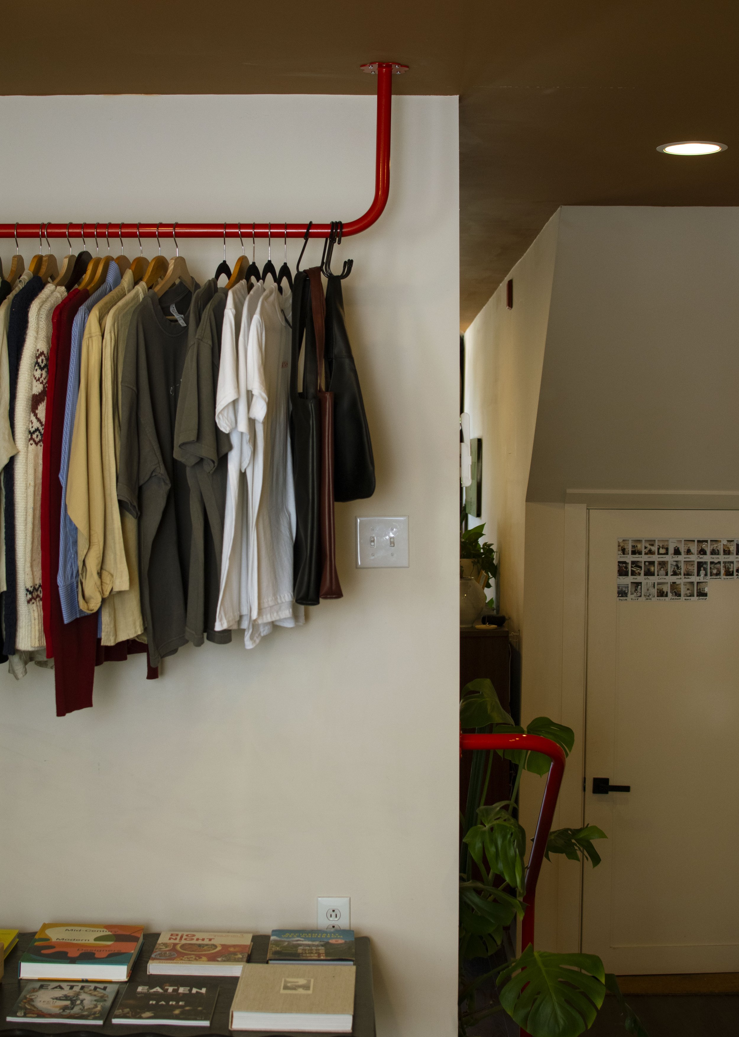 Red clothing bar mounting into tan ceiling