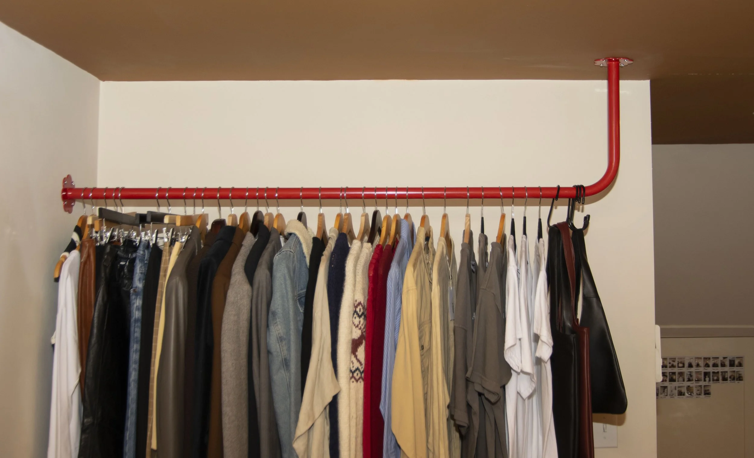 Red clothing bar mounting into tan ceiling