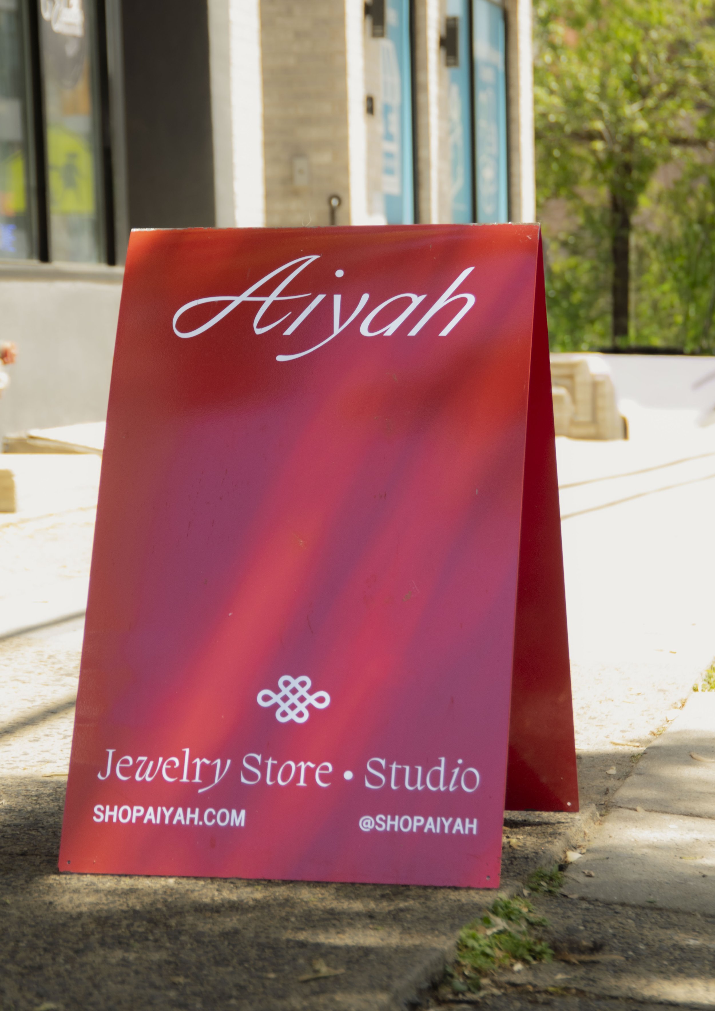 Red A frame sign with Aiyah business information applied to it