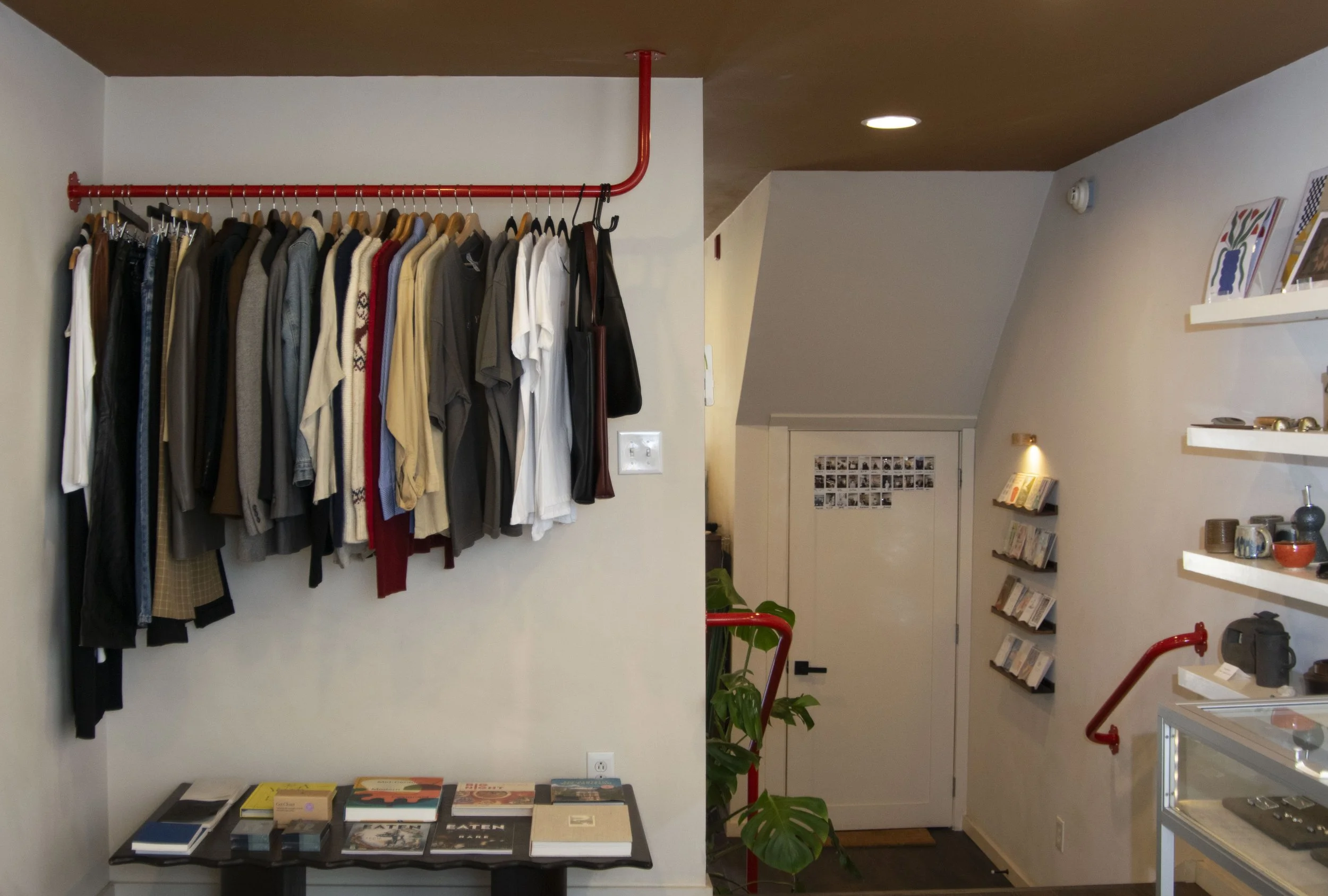 Red clothing bar mounting into tan ceiling
