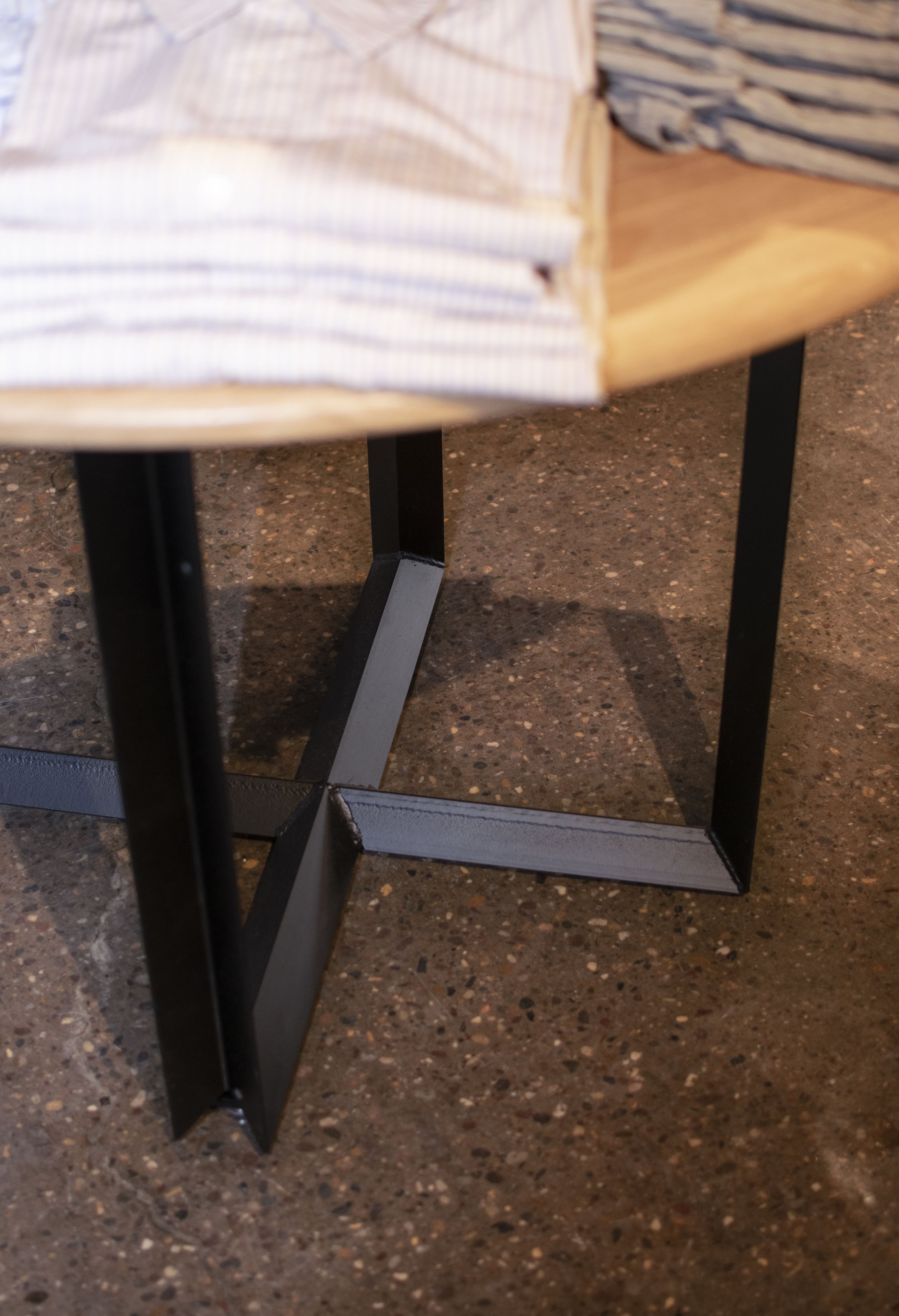 Detail of angle iron steel meeting in a cross arrangement as a table base.