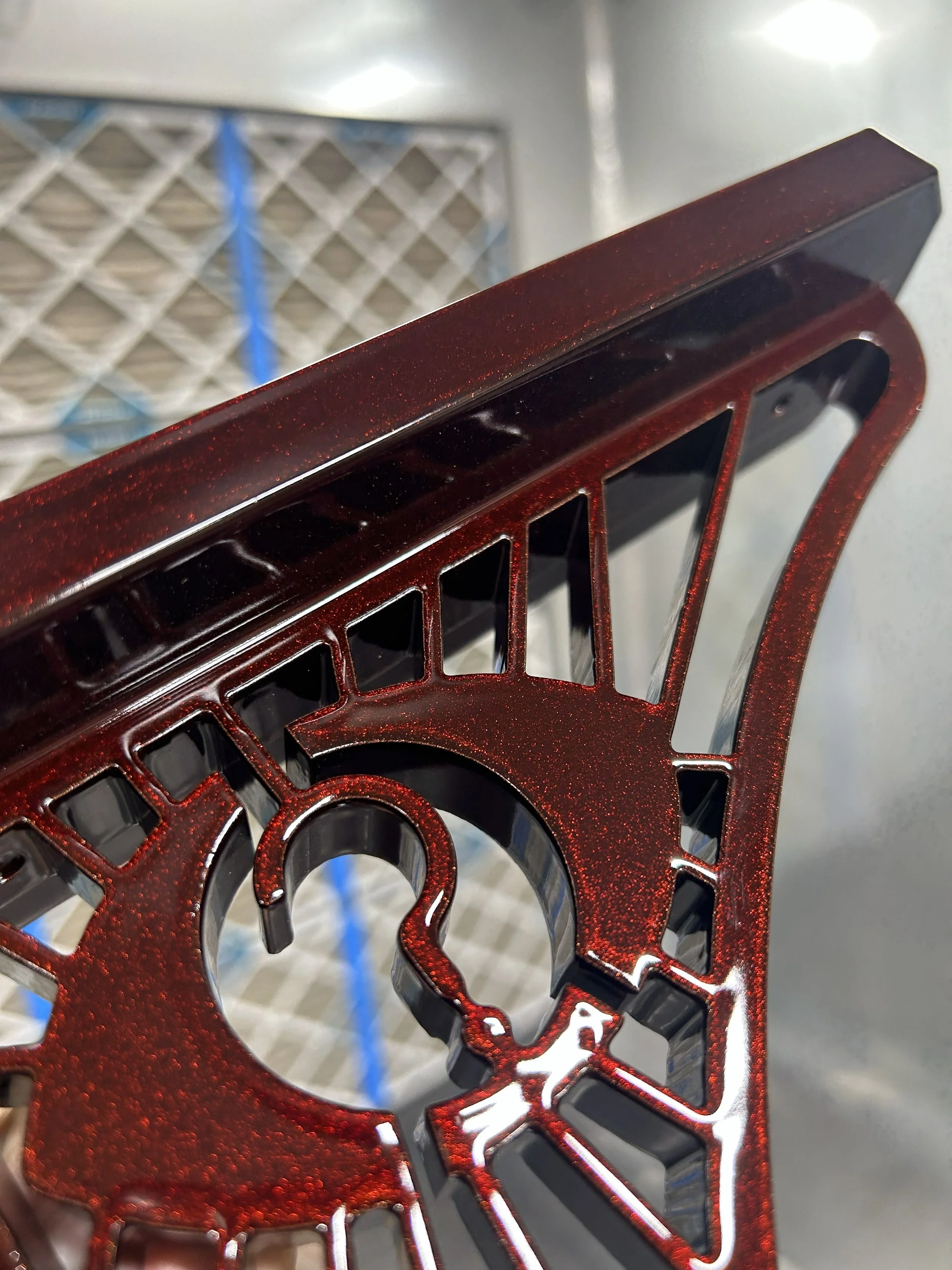 Close-up of a metallic red shelf bracket with eye and question mark cutout.