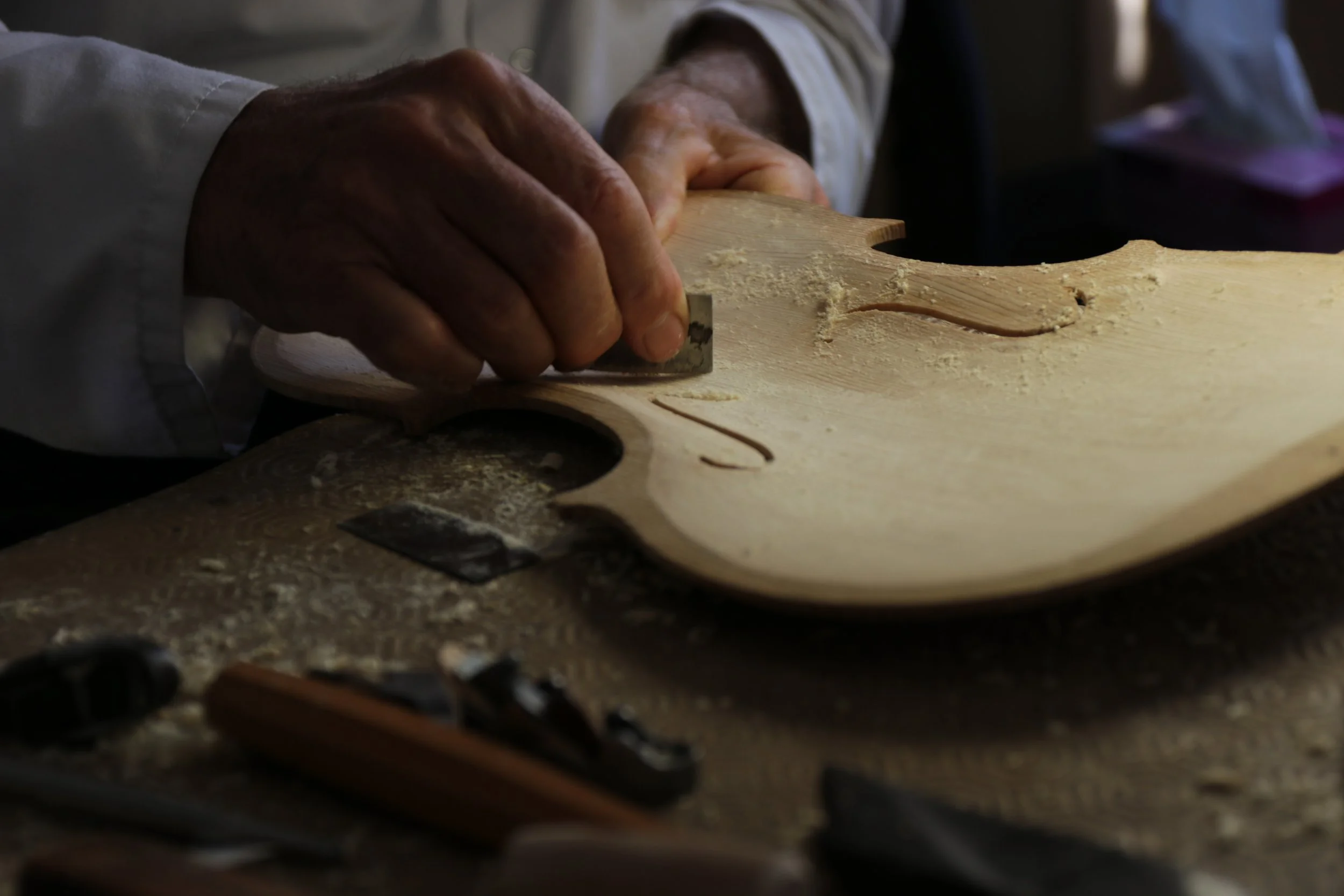 Une personne utilise un outil pour sculpter ou tailler du bois dans un atelier.