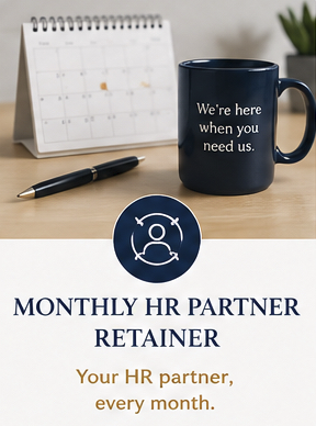 A desk calendar, a black pen, and a navy blue mug with white text that reads 'We're here when you need us.' Next to these on the desk is a flyer or brochure titled 'Monthly HR Partner Retainer' with a subtitle 'Your HR partner, every month' and an icon of a person's head and shoulders.