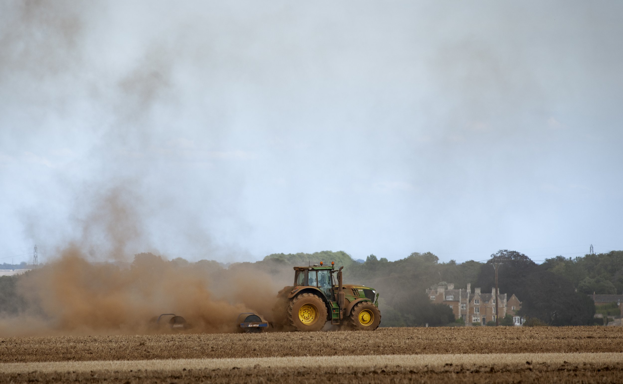 Turning the stubble back in among plumes of soil dust catching the breeze, near Ridlington